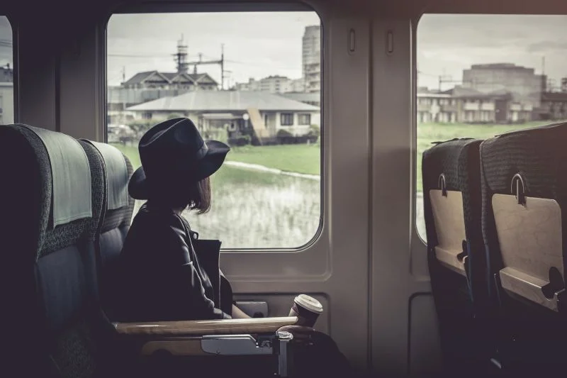 Žena s kávou vo vlaku sleduje výhľad